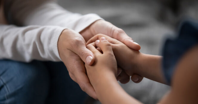 Mains de parent et enfants