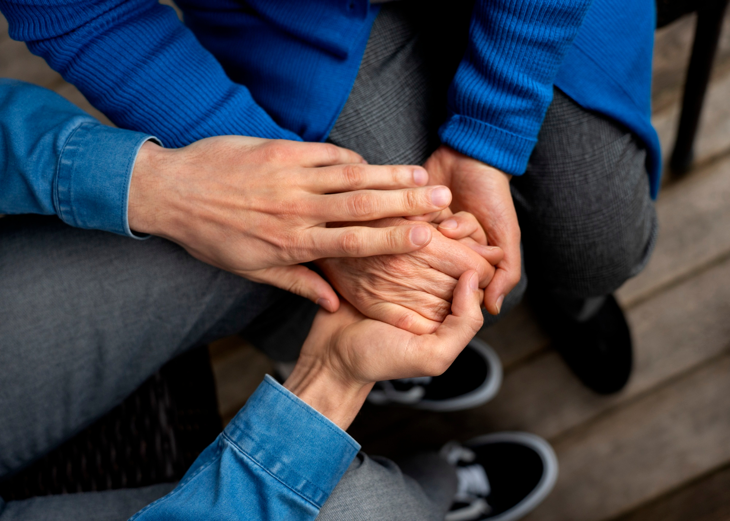 Close-up van een man die de hand van een oudere persoon vasthoudt