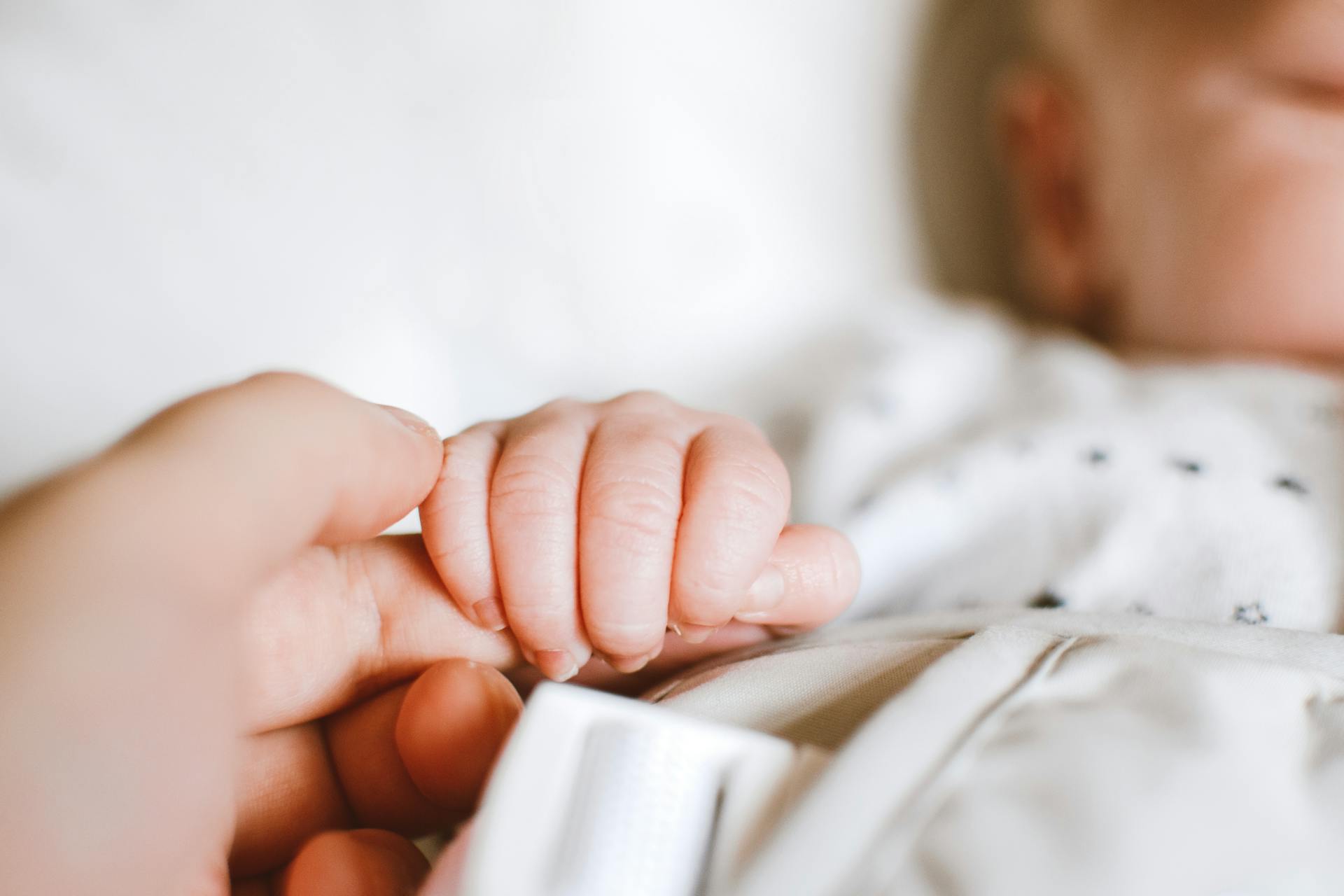 Een baby die iemands vinger vasthoudt | Bron: Pexels